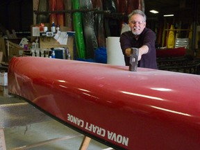 Tim Miller, president of Nova Craft Canoe, uses a sledge hammer to demonstrate the resiliency of a canoe made of TuffStuff. (DEREK RUTTAN, The London Free Press)