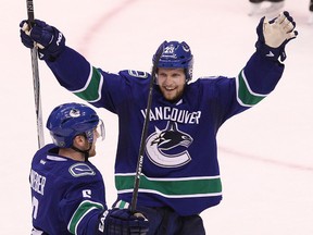 Vancouver Canucks' Alexander Edler (right) congratulates teammate Yannick Weber (left) after scoring a goal against Winnipeg Jets during the second period of NHL game at Rogers Arena in Vancouver, B.C. on Tuesday March 24, 2015. Carmine Marinelli/QMI Agency
