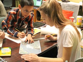 Hanna Memorial student Jakob Wildschut pores over a map of Niagara Falls with Bright's Grove Public student Jenna Wilkins at DeGroot's Nurseries on Wednesday March 25, 2015 in Sarnia, Ont. Enrichment students from across Sarnia-Lambton were tasked with building an observation deck for the tourist attraction during a day-long workshop led by Gilchrist Architecture. (Barbara Simpson/Sarnia Observer/QMI Agency)