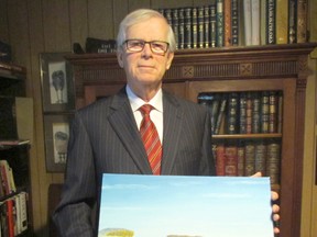 Ontario Superior Court Justice Joseph Donohue holds a painting depicting life during an earlier time in Kugluktuk, Nunavut on Wednesday March 25, 2015 in Sarnia, Ont. Donohue has made seven trips to Nunavut where he is a volunteer deputy judge.  (Paul Morden/Sarnia Observer/QMI Agency)