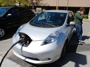 Justin Miller makes a phone call as he charges his 2013 Nissan Leaf electric carin Salt Lake City, Utah, in this April 30, 2014 file photo. (REUTERS/George Frey/Files)