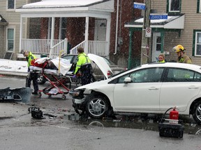 Patient taken away by EMS at the scene of a motor vehicle collision at Johnson and Albert Streets involving two moving vehicles and a parked one in Kingston, Ont. on Thursday March 26, 2015. Steph Crosier/Kingston Whig-Standard/QMI Agency