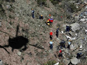 Investigators work amongst the debris of the Airbus A320 at the site of the crash, near Seyne-les-Alpes, French Alps. A young German co-pilot locked himself alone in the cockpit of Germanwings flight 9525 and set it on course to crash into an Alpine mountain, killing all 150 people on board including himself.  (REUTERS/Emmanuel Foudrot)