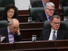 Health Minister Stephen Mandel (left) and Education Minister Gordon Dirks read as Alberta Finance Minister Robin Campbell delivers Budget 2015 in the Alberta Legislature in Edmonton, Alta., on Thursday, March 26, 2015. Ian Kucerak/Edmonton Sun/ QMI Agency