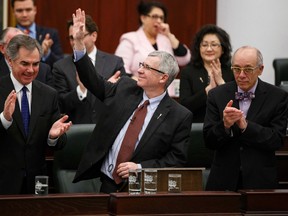 Alberta finance minister Robin Campbell (centre) is applauded by the government benches after delivering Budget 2015 in the Alberta Legislature in Edmonton, Alta., on Thursday, March 26, 2015. Ian Kucerak/Edmonton Sun/ QMI Agency