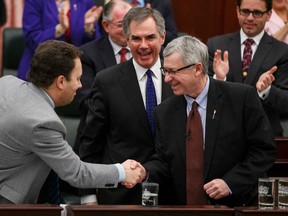 Finance minister Robin Campbell shakes hands with Minister of Justice and Solicitor General Jonathan Denis while Premier Jim Prentice looks on, at the Alberta Legislature on Thursday.  (Ian Kucerak/Edmonton Sun)