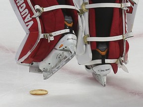 Senators goalie Andrew Hammand steps over a hamburger after a recent game. (Tony Caldwell/Ottawa Sun)