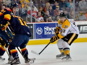 Erie Otters' Remi Elie, left, and Erie Otters' Alex DeBrincat look on as Sarnia Sting's Anthony Salinitri looks to take possession of the puck on March 26 during the first round of the OHL playoffs at Erie Insurance Arena. (SARAH CROSBY, contributed photo)