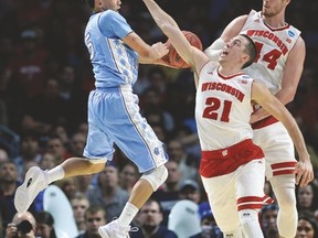North Carolina’s Marcus Paige looks for the pass against two Wisconsin players last night. (USA TODAY SPORTS)