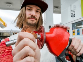Gas buyer Mac Sampson holds four cents after filling up his truck with fuel at at Shell station on 17 Ave SW in Calgary, Alta., on Thursday, March 26, 2015. The gas tax went up four cents at midnight, up to $0.13 per litre from $0.09. Lyle Aspinall/Calgary Sun/QMI Agency