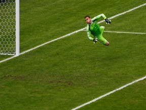 Russia goalkeeper Igor Akinfeev jumps during the World Cup in Rio de Janeiro last June. During a Euro 2016 qualifier in Montenegro on Friday, Akinfeev was hit the head by a flare in the first minute of play and was removed from the game. (Ricardo Moraes/Reuters/Files)