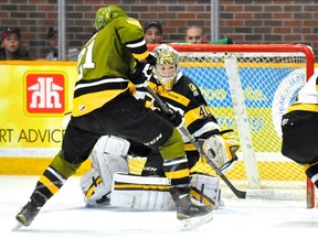 Nick Paul of the North Bay Battalion tries to make contact with the loose puck as KIngston Frontenacs goalie Lucas Peressini and defenceman Chad Duchesne look on during Game 1 of an OHL Eastern Conference quarter-final playoff series in North Bay Friday night. (Sean Ryan/Brampton Battalion)