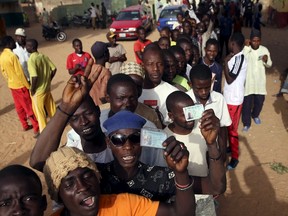 Men holds ID cards as they wait in line to register to vote in a polling station during elections in Kano, Nigeria, March 28, 2015. (GORAN TOMASEVIC/Reuters)