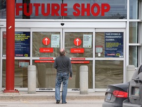 A man reads signs posted on the door of the Future Shop location on Leila Avenue in Winnipeg, Man., on Sat., March 28, 2015. Three Future Shops in Winnipeg closed suddenly and for good on Saturday, with the Pembina Highway location to reopen under the Best Buy banner.