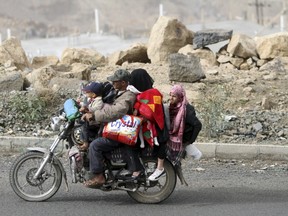 A man flees with his family and their belongings on a motorcycle in Sanaa March 28, 2015. An Arab alliance attacking Shi'ite Muslim Houthi forces in Yemen initially plans a month-long campaign, but the operation could last five or six months, a Gulf diplomatic official said on Saturday. REUTERS/Mohamed al-Sayaghi