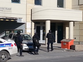 Police in tactical gear swarmed a busy Hintonburg intersection Saturday, March 28, 2015 following a standoff with a man barricading himself in an apartment.
Police evacuated the seventh floor of Hintonburg Place — an Ottawa Community Housing property at 395 Parkdale Ave. on the corner of Wellington St. — while they attempted to speak with a man
AEDAN HELMER/OTTAWA SUN/QMI AGENCY