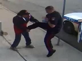 Screenshot of video showing Regina cop kicking homeless man. 

(YouTube/TheLadBuzz)