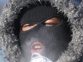 Jesse Ferrara tries to keep warm on his walk home on St. Laurent Blvd after work in Ottawa Friday Feb 13, 2015. Temperatures reached as low as -40 with the windchill  Friday.  
Tony Caldwell/Ottawa Sun/QMI Agency