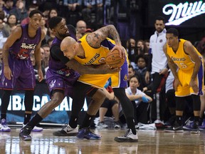 Raptors forward Amir Johnson (left) defends against Lakers centre Robert Sacre at the Air Canada Centre on Friday. Toronto clinched the Atlantic Division title with a victory despite a lackluster performance that elicited first-half boos from the fans. (USA Today Sports)