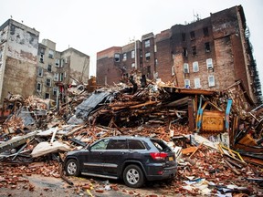 A car sits amongst the rubble after an explosion destroyed four buildings in New York March 27, 2015. Two people remained unaccounted for in the wake of an apparent gas explosion that destroyed four New York City apartment buildings and injured 19 people, police said. REUTERS/Nancy Borowick/Pool