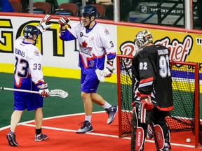 Kasey Beirnes (left) and Brock Sorensen of the Toronto Rock celebrate a late game-tying goal on Calgary Roughnecks goaltender Frankie Scigliano during NLL action in Calgary on Saturday night. The Rock won the game 12-10. (Lyle Aspinall/QMI Agency)