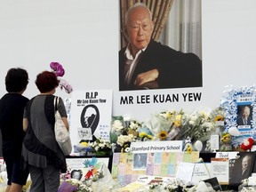 People pay their respects to the late first prime minister Lee Kuan Yew at a community tribute site in Singapore March 28, 2015. Thousands of Singaporeans queued to pay their last respects to former prime minister Lee Kuan Yew, who lay in state at Parliament House, waiting for up to ten hours in stifling tropical heat to view his body. REUTERS/Edgar Su