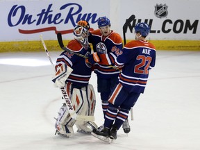 Richard Bachman is congratulated by Oscar Klefbom (84) and Keith Aulie (22) after his shutout against the Dallas Stars on Friday, March 27, 2015. PERRY MAH/Edmonton Sun