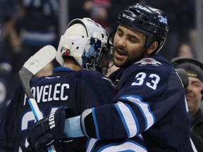 Winnipeg Jets defenseman Dustin Byfuglien (33) celebrates with goalie Ondrej Pavelec (31) after their game against the Montreal Canadiens at MTS Centre. (James Carey Lauder-USA TODAY Sports)