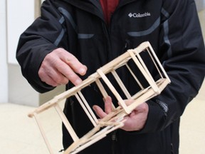 David Murray, a volunteer student advisor who visited classrooms across Lambton in preperation for the bridge building competition, examines one model on Saturday March 28, 2015 in Sarnia, Ont. Neil Bowen/Sarnia Observer/QMI Agency