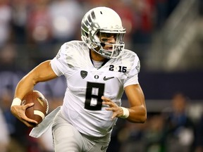 Quarterback Marcus Mariota #8 of the Oregon Ducks runs the ball against the Ohio State Buckeyes during the College Football Playoff National Championship Game at AT&T Stadium on January 12, 2015 in Arlington, Texas. (Ronald Martinez/Getty Images/AFP)