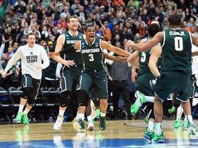 Michigan State players celebrate after defeating Louisville to reach the Final Four on Sunday. (USA TODAY SPORTS)