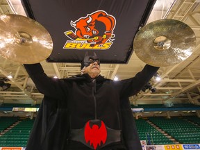 The Dark Knight raises his cymbals at centre ice in Yardmen Arena in Belleville, Ont. Wednesday, March 25, 2015. John Wilson's fandom for the Belleville Bulls has led him to amass dozens of costumes, including several superheroes, to be worn to games. - Luke Hendry/The Intelligencer/QMI Agency