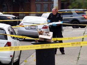 Edmonton Police Service members investigates the area of a shooting where Alor Deng was found dead on the street on 81 Ave., and Calgary Trail in Edmonton, Alberta on July 20, 2014.  Sean Jennings, 27, was charged with second degree murder and four other firearms-related charges in relation to the Deng homicide. Perry Mah/Edmonton Sun/QMI Agency