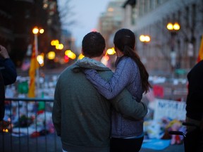 A couple embraces at a memorial on Boylston Street to the victims of the Boston Marathon bombings in Boston, Massachusetts April 21, 2013.  Two explosions hit the Boston Marathon on April 15 killing at least three people and injuring over 100 others. (REUTERS/Brian Snyder)