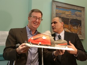 Mayor of Ottawa Jim Watson and Osgoode city councillor George Darouze hold up a snowmobile cake about to be cut celebrating Watson's return to his duties at Ottawa City Hall on Monday, Mar. 30, 2015. Watson is back on a part-time basis as he recovers from a broken pelvis sustained in a snowmobile accident. Andrew Meade/Ottawa Sun