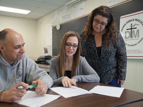 Durham Catholic District School Board teachers Peter Hanlon and Susana Pereira work with student Amanda Moore at the Durham College Centre for Success, a high school within a college.