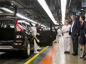 Production Associate Ronda St. Pierre speaks to Prime Minister Stephen Harper who is with Kellie Leitch, Minister of Labour and Minister of Status of Women, as they tour a Honda manufacturing plant in Alliston, Ont., March 30, 2015.  (REUTERS/Fred Thornhill)