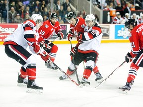 Brendan Perlini of the Niagara IceDogs and Nathan Todd of the Ottawa 67's fight for the puck in first period at the Meridian Centre in St. Catharines on Monday, March 30, 2015.  (Julie Jocsak/ St. Catharines Standard/ QMI Agency)