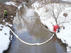 Workers from KRT secure a containment boom into place on Junction Creek near downtown Sudbury on Monday March 30, 2015. Around 25 litres of oil has spilled into the creek. The city is monitoring the spill and continue investigating the source of the contaminates.  Gino Donato/Sudbury Star