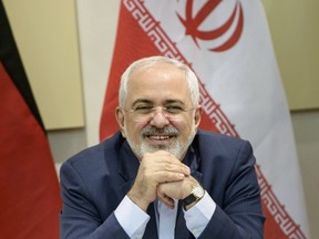 Iranian Foreign Minister Javad Zarif smiles as he waits for the start of a meeting with P5+1, European Union and Iranian officials at the Beau Rivage Palace Hotel in Lausanne March 30, 2015, during Iran nuclear talks. REUTERS/Brendan Smialowski/Pool