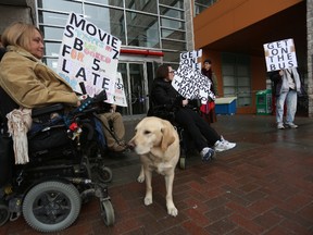 Joy Tomkinson, left, and Jenn Abrams sit outside the entrance to City Hall on Monday, Mar. 30, 2015 with fellow Para Transpo users. The group says that services from the system are inadequate andis rallying to get the city to increase Para Transpo services and accessibility. Andrew Meade/ Ottawa Sun