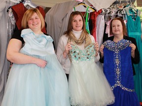 Beth Fudge, Debbie Anderson and Tracy Ranick show off samples of some lightly-worn dresses recently collected for the Cinderella Story of Sarnia-Lambton, in this file photo. The organization provides prom and graduation dresses to young women in Grades 8 and 12 who would normally not be able to afford them. More than 820 donated dresses are available at the April 10 and 11 boutique. (File photo)