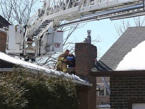 Ottawa firefighters helped rescue a mentally disabled teenager off a roof on Snowy Owl Trial in Ottawa Tuesday March 31, 2015. After the teenager trashed the house she made her way on to the roof where she needed to be rescued. (Tony Caldwell/Ottawa Sun/QMI Agency)