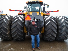 Mike Hathaway of Advantage Farm Equipment on Colonel Talbot Rd. southwest of London, sits on the rear hitch of a $350,000, 450 horsepower CAT tractor, that Hathaway says will pull just about any piece of farm equipment with the eight drive wheels keeping the giant tractor from leaving too deep a footprint. (MIKE HENSEN, The London Free Press)