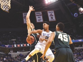 Duke guard Quinn Cook makes a pass against Michigan State forward Matt Costello when the two teams met earlier this season. (USA TODAY SPORTS)