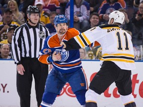 Matt Hendricks, shown here squaring off against Boston centre Gregory Campbell this season, is a member of the team’s ‘Wagon Line’ and is described by coach Todd Nelson as a player who tries to play the game right. (Codie McLachlan, Edmonton Sun)