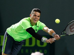 Milos Raonic hits a backhand against John Isner (not pictured) on day nine of the Miami Open at Crandon Park Tennis Center.  Mandatory Credit: Geoff Burke-USA TODAY Sports