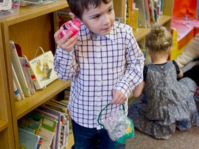 Four-year-old Carter Cheff shakes to hear what is inside his Easter egg during the Cochrane Public Library's 11th annual Easter Egg Hunt.