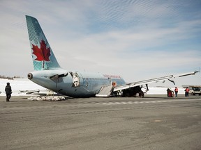 Transportation Safety Board investigators work at the crash site of Air Canada flight 624 that crashed early Sunday morning during a snowstorm, at Halifax Stanfield International Airport in Enfield, Nova Scotia, March 30, 2015. The Air Canada plane landed short of the runway and hit an antenna array, losing its landing gear, safety officials said. REUTERS/Andrew Vaughan/Pool