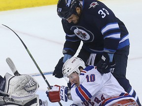 Winnipeg Jets defenceman Dustin Byfuglien (top) cross-checks New York Rangers centre J.T. Miller in the back of the neck during NHL action at MTS Centre on Tuesday night. Byfuglien faces a suspension for the cross-check. (Kevin King/Winnipeg Sun)